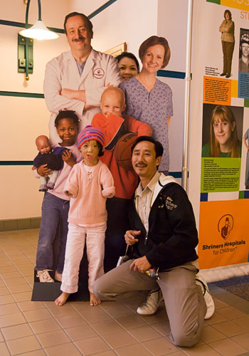 Boun Lod, Noy, and Via mugging with a cutout at the Shriners Hospital.